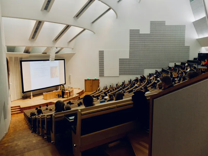 Hörsaal mit Professor:In und Studierenden